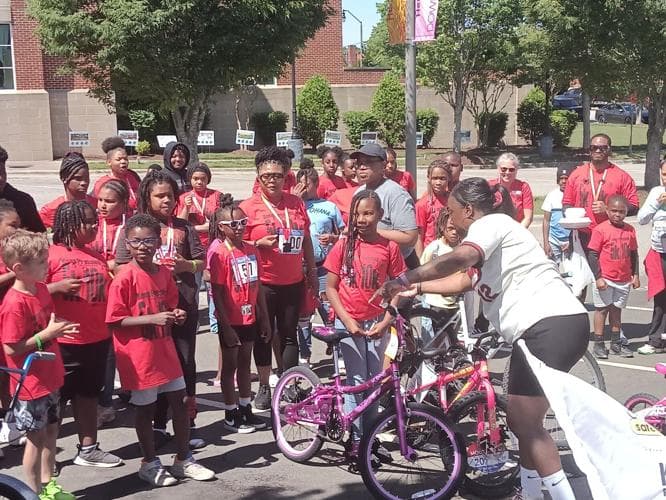 Youth in red shirts gathered for a bike raffle at the AIMHigh event