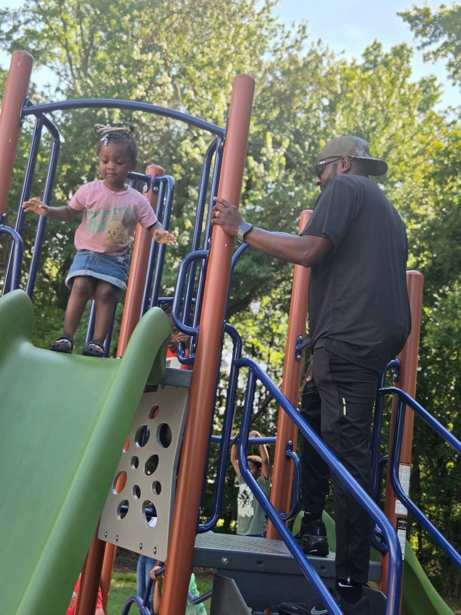 CJ helping a child on a playground at Chestnut Street Park